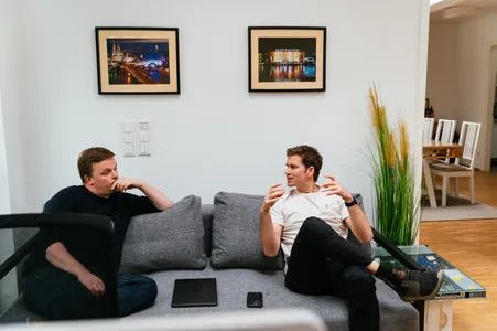 Axel und Christian führen ein Gespräch auf der Couch.